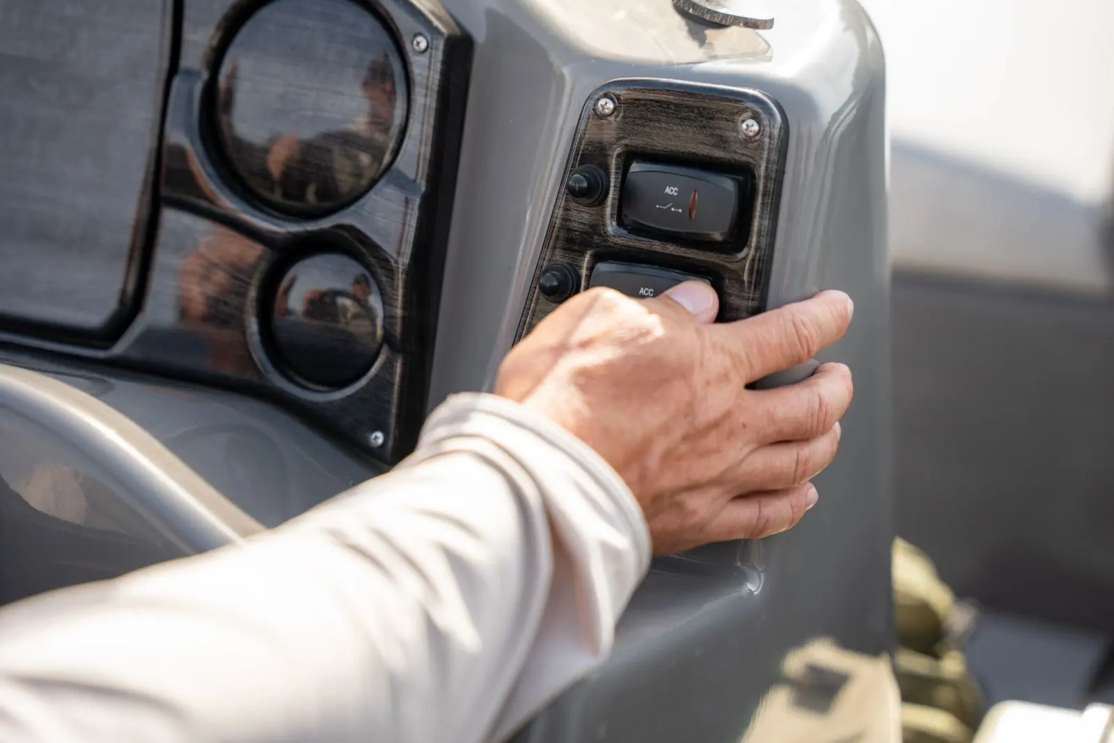 A hand on the rocker switches at the Leisure Quest helm