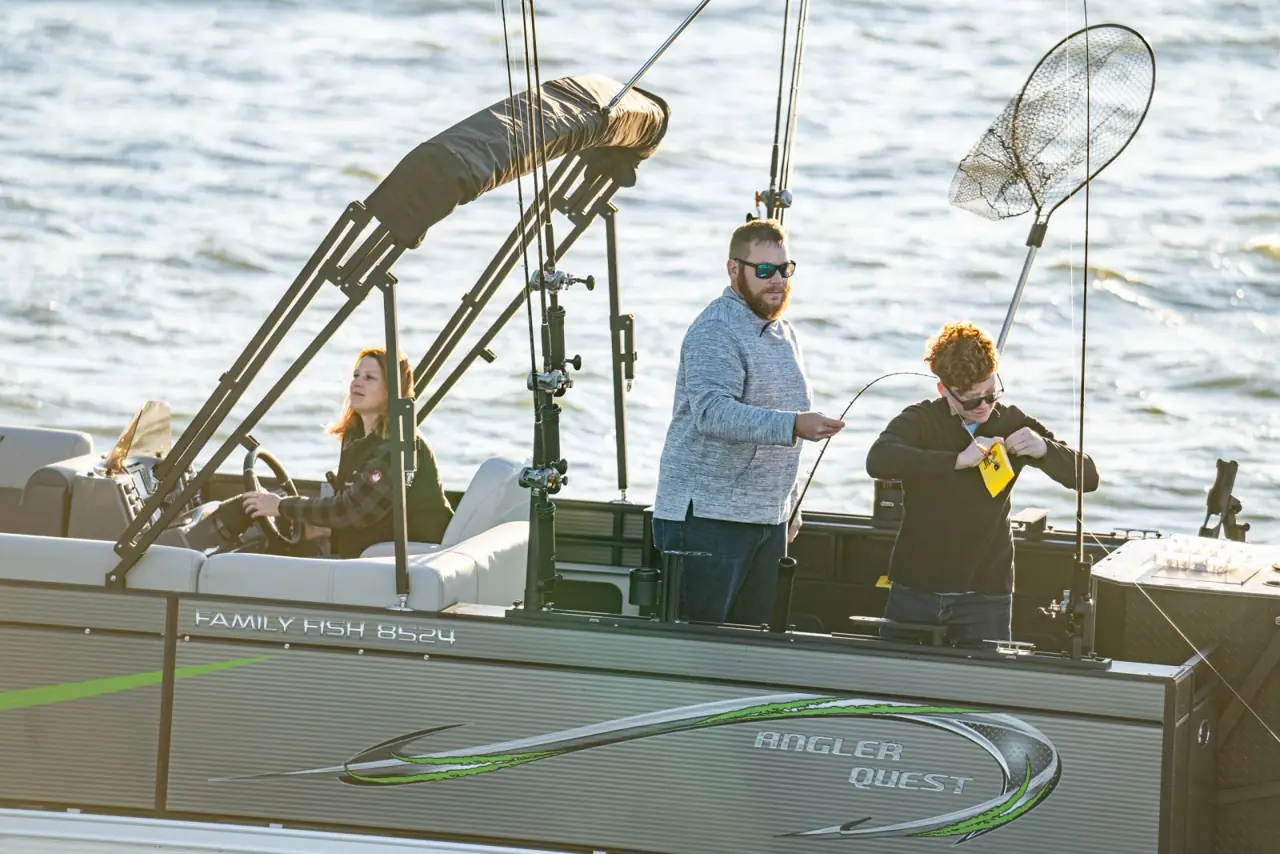 Anglers netting a fish at the stern of the Pro Family Fish