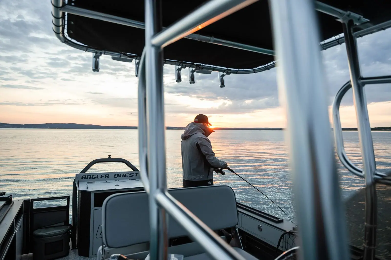 An angler casting at sunrise, framed by the T-top of a Pro Fish N’ Cruise